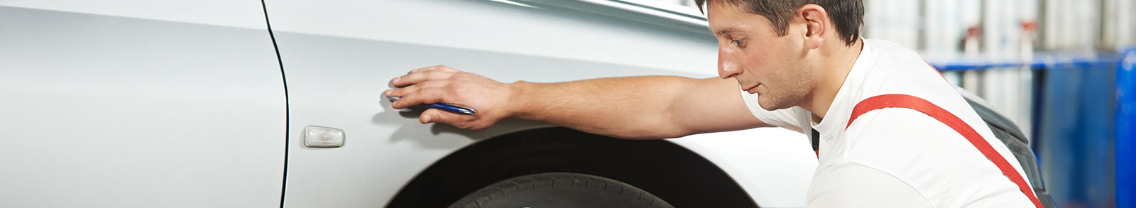 Mechanic inspecting a car with clipboard