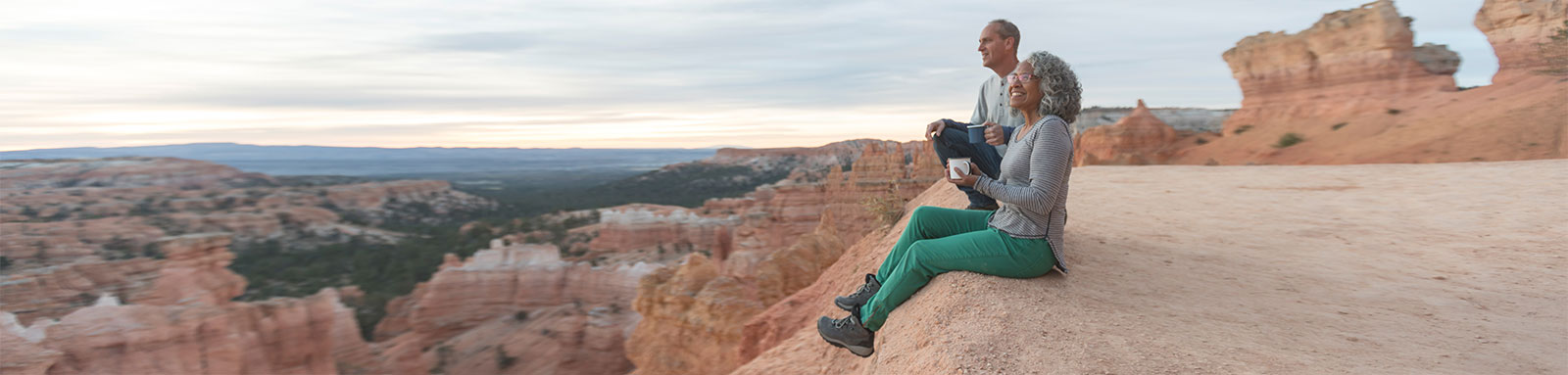 Elderly couple sitting on top of canyon