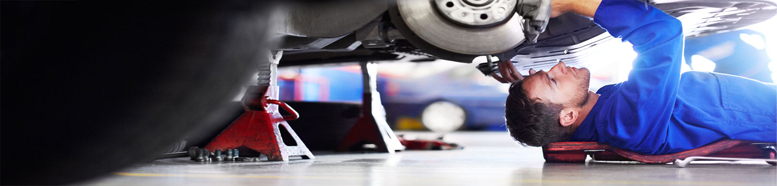 Car service mechanic under a car