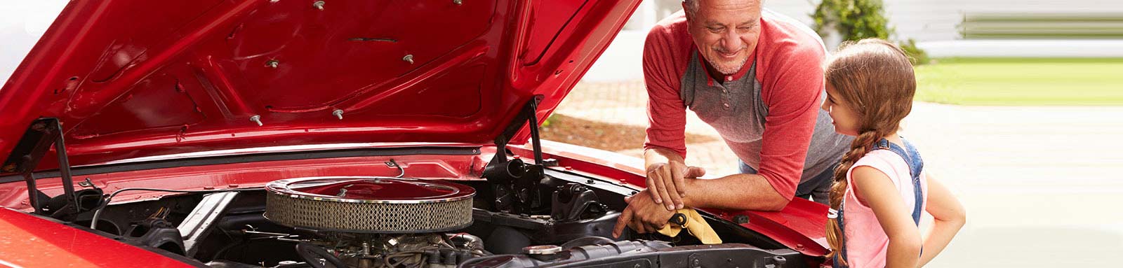 Grandad and grandaughter fixing red car