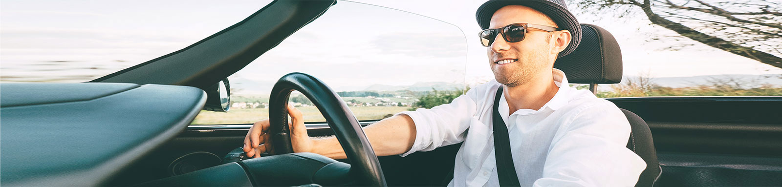 Man driving convertible car in countryside