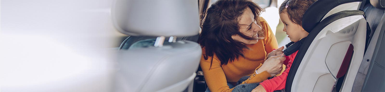 Mum putting baby in car seat