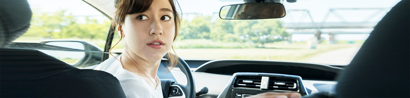 Young woman driver looking at the back seat