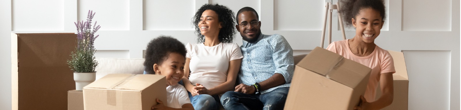 kids playing with moving boxes while parents sit on couch