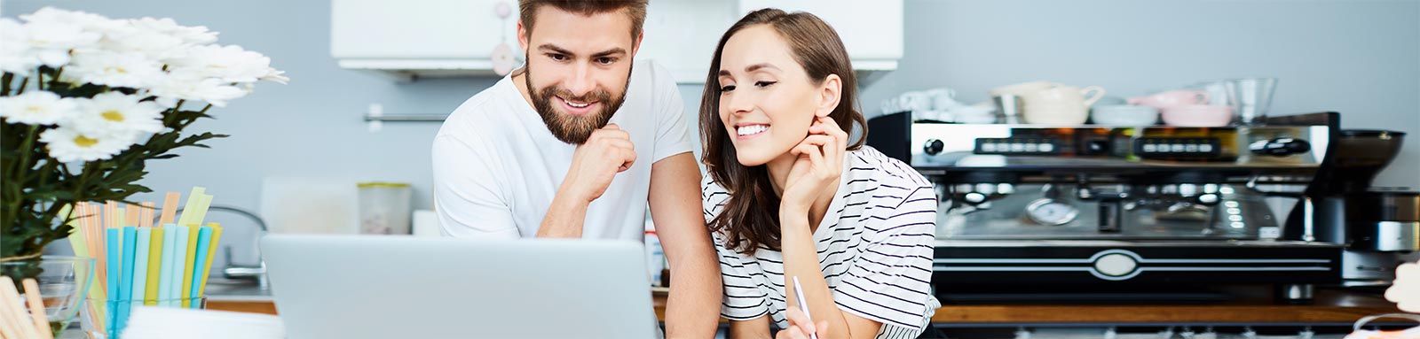 A couple sitting in front of computer in cafe