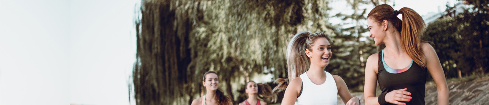 group of teen girls jogging in park