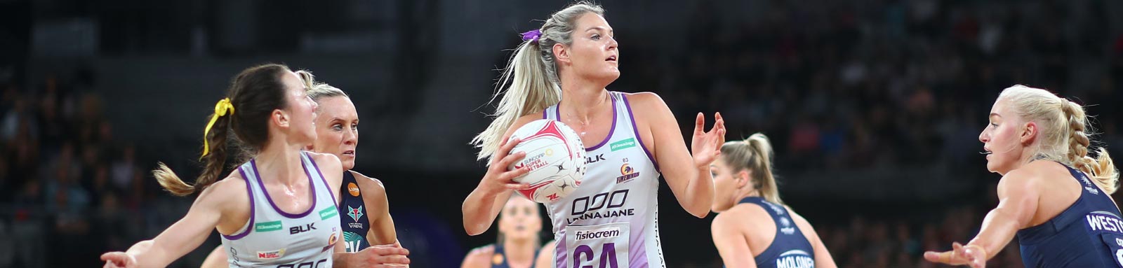 Professional netballers playing on court