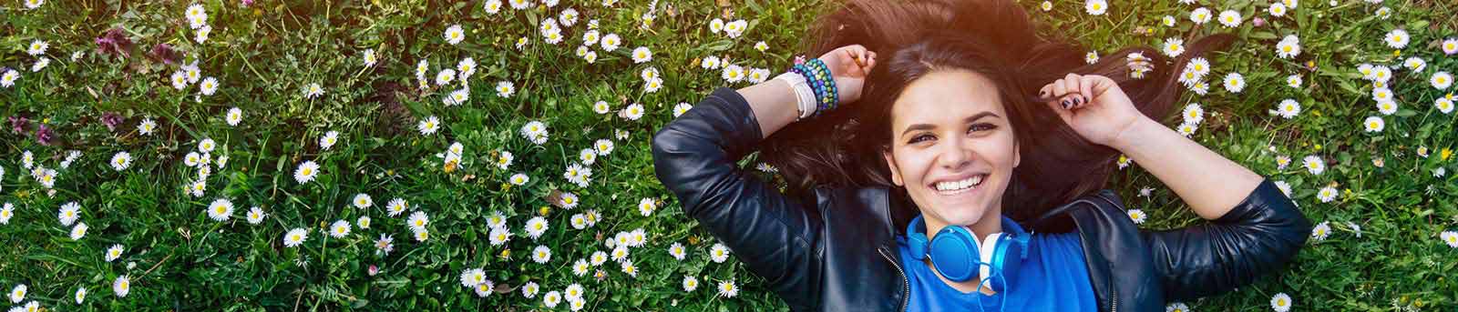 Girl lying on the grass with headphones