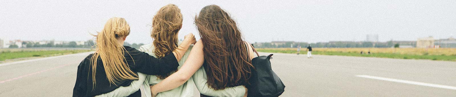 3 girls walking on the road in arms