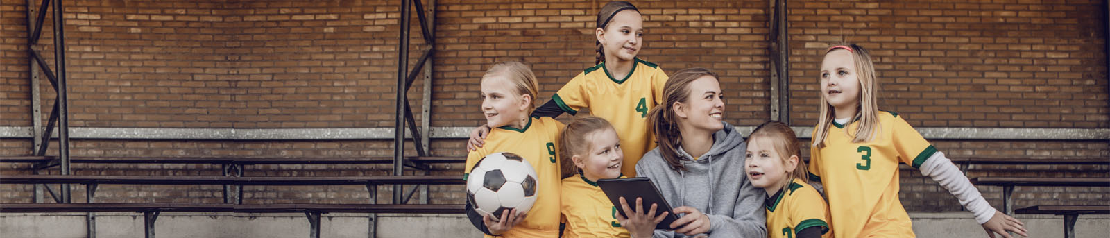 Young Blonde Female Soccer Coach and her Girl Football team