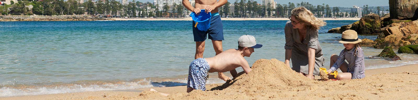 Family building a sand castle on the beach