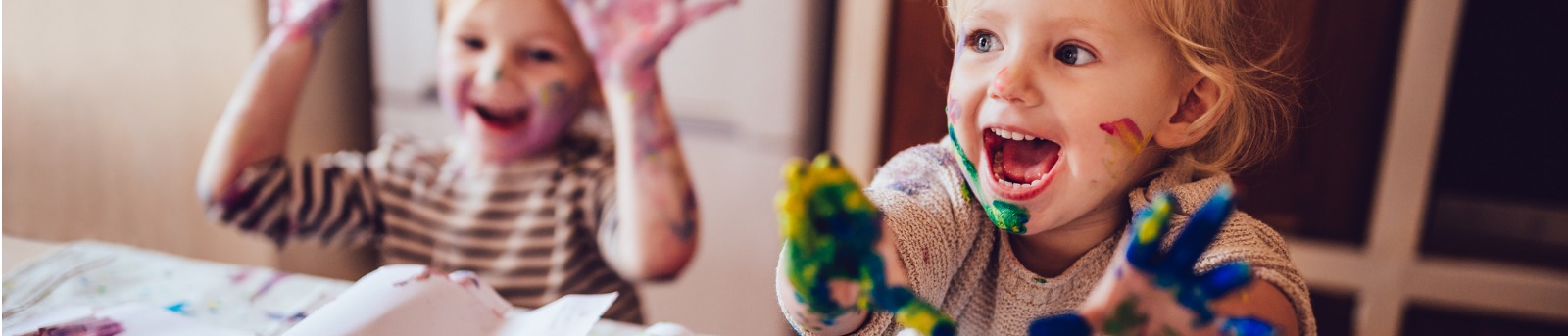Toddlers finger painting messily at home 