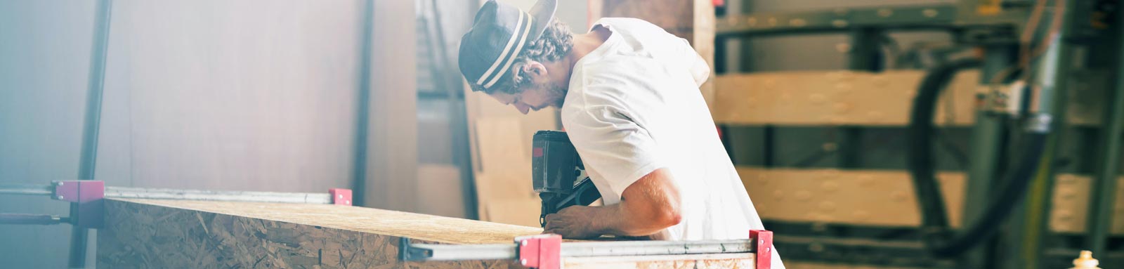 A man is  cutting wood with machine.