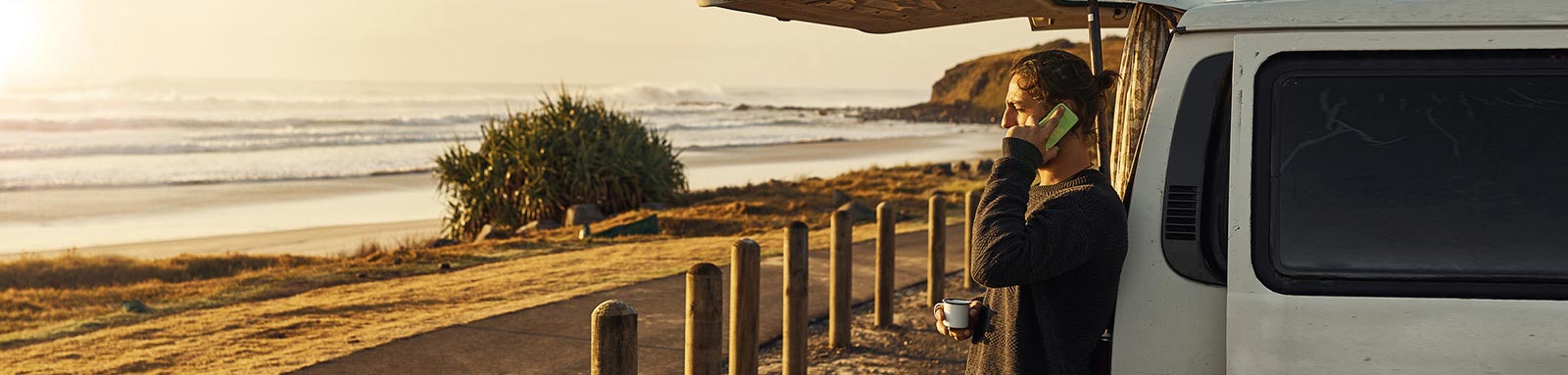 Man on phone looking on at the beach