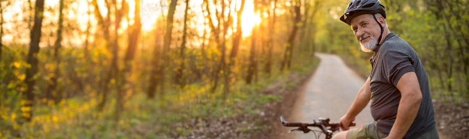 A man with his bike in woods.