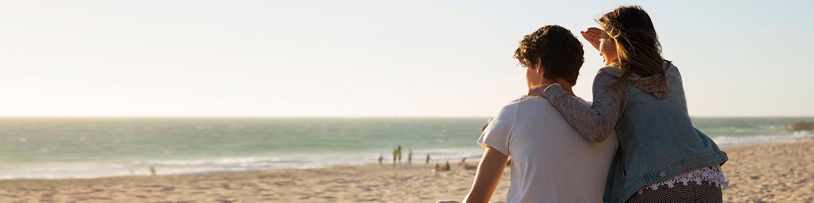 Couple sitting on the beach watching surf