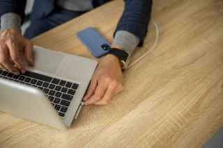 laptop charging phone on table